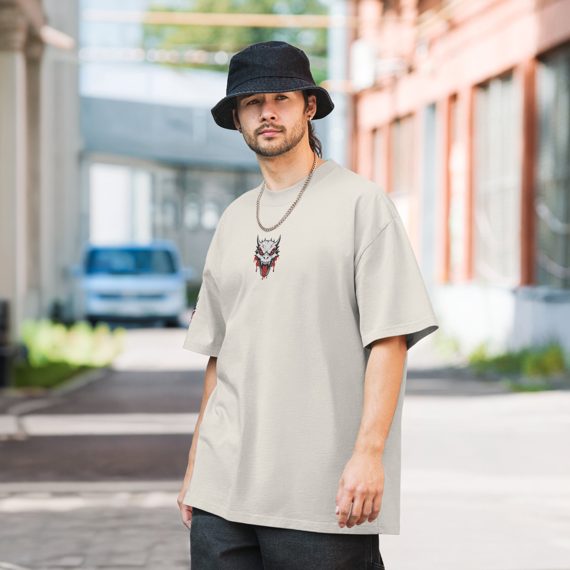 Man wearing a beige t-shirt with a graphic design outdoors