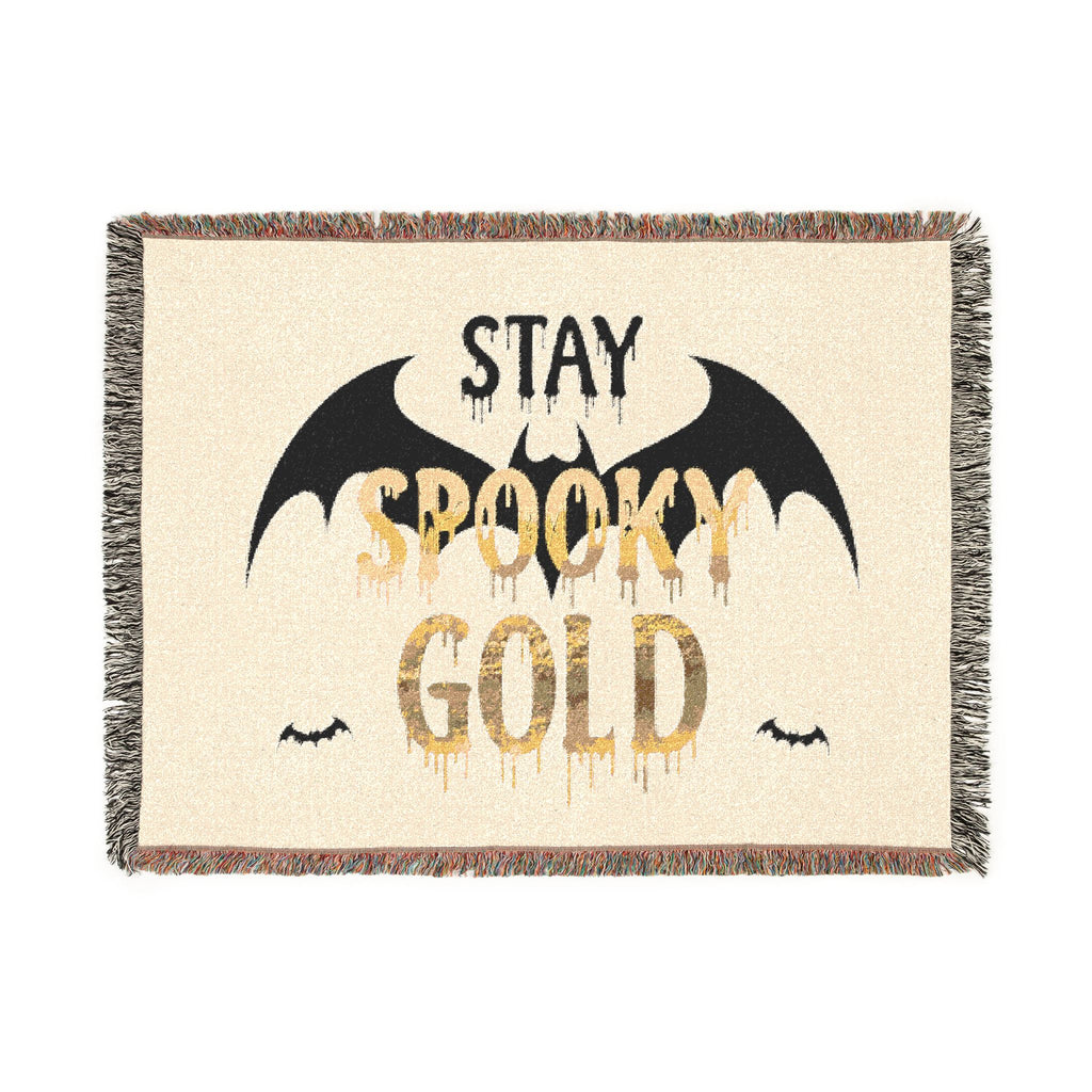 Blanket with 'Stay Spooky Gold' text and bat designs on a beige background