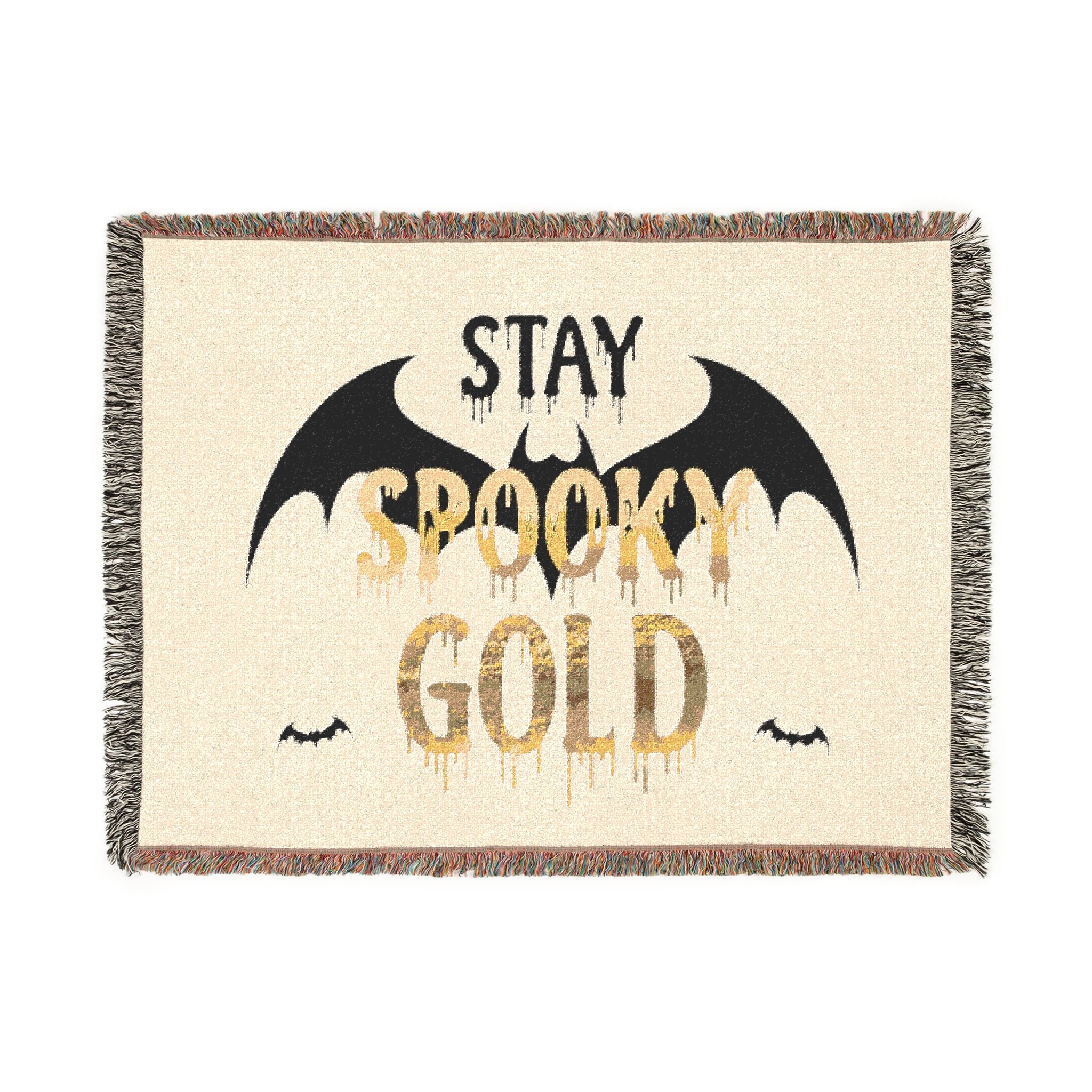 Blanket with 'Stay Spooky Gold' text and bat designs on a beige background