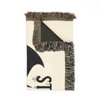 Woven blanket with geometric pattern and fringe on a white background