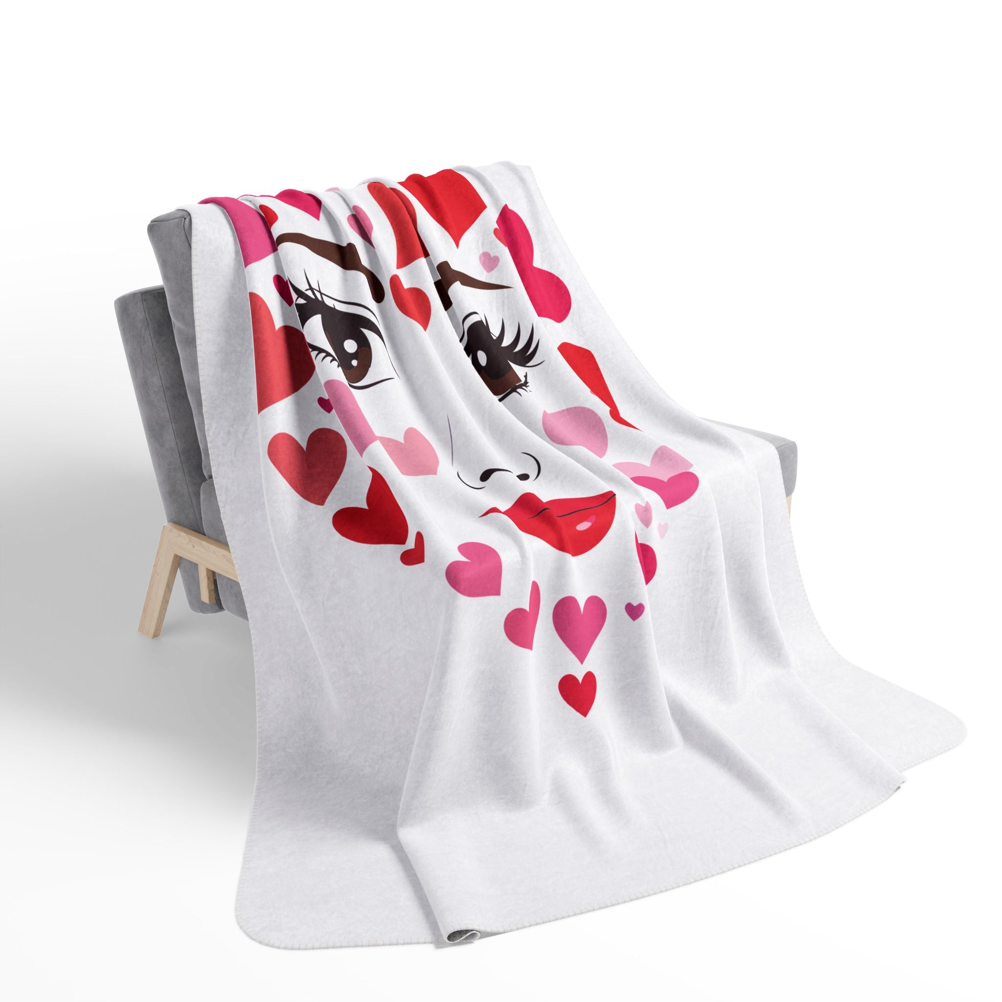 White blanket with cartoon face and hearts draped over a chair on a white background