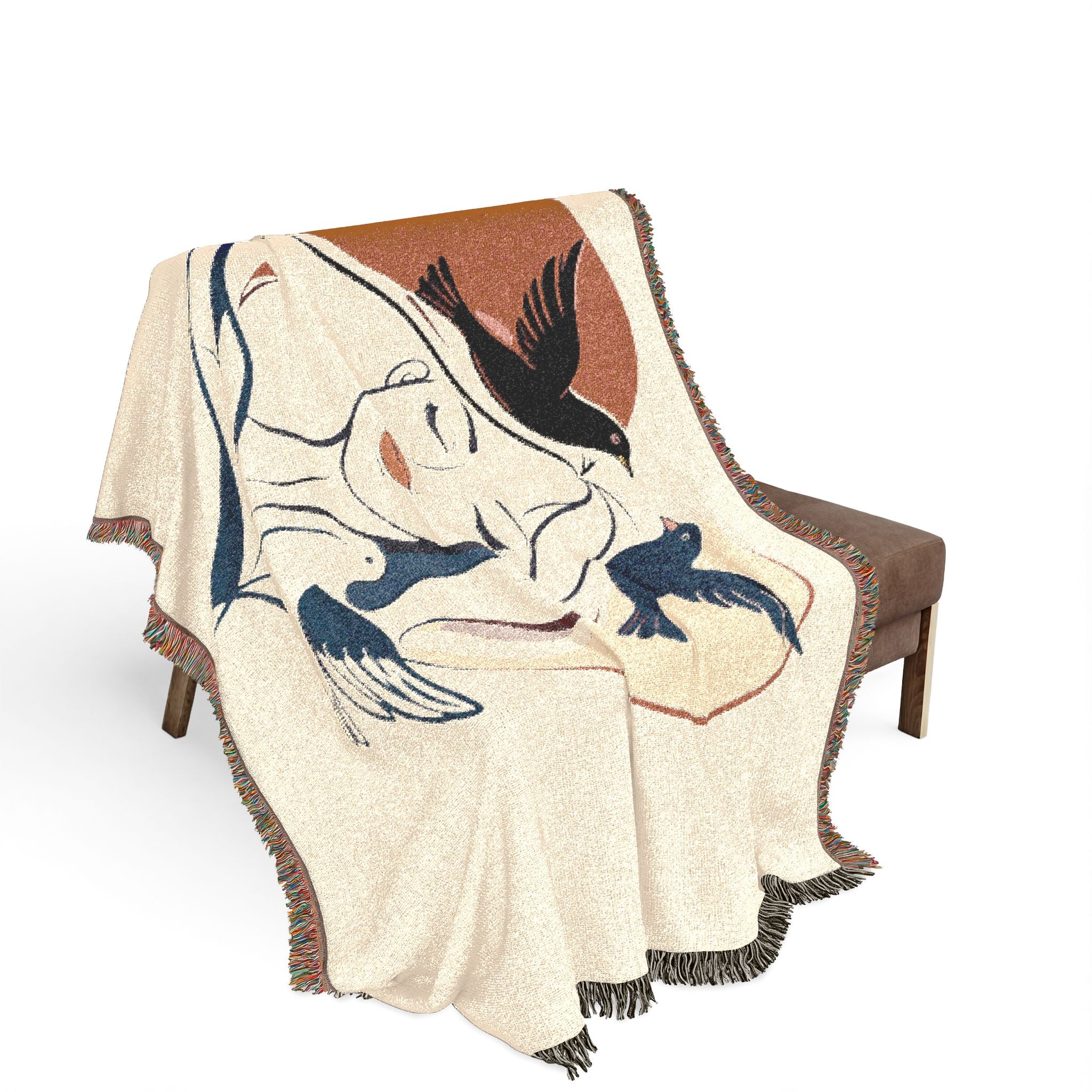 Decorative blanket with bird design draped over a chair on a white background