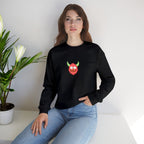 Woman wearing a black sweatshirt with a colorful graphic design sitting on a white surface with a plant in the background.