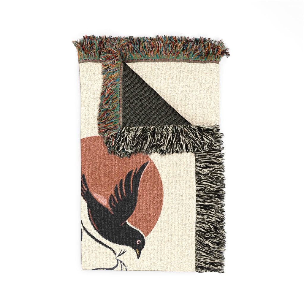 Woven blanket with bird design and fringed edges on a white background