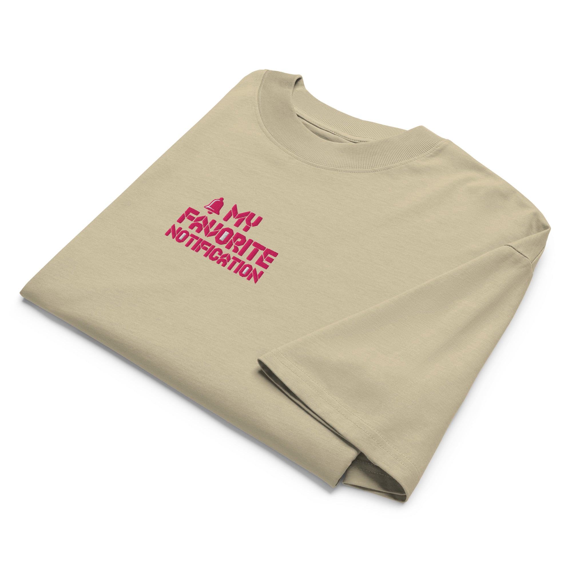 Folded beige t-shirt with red text on a white background