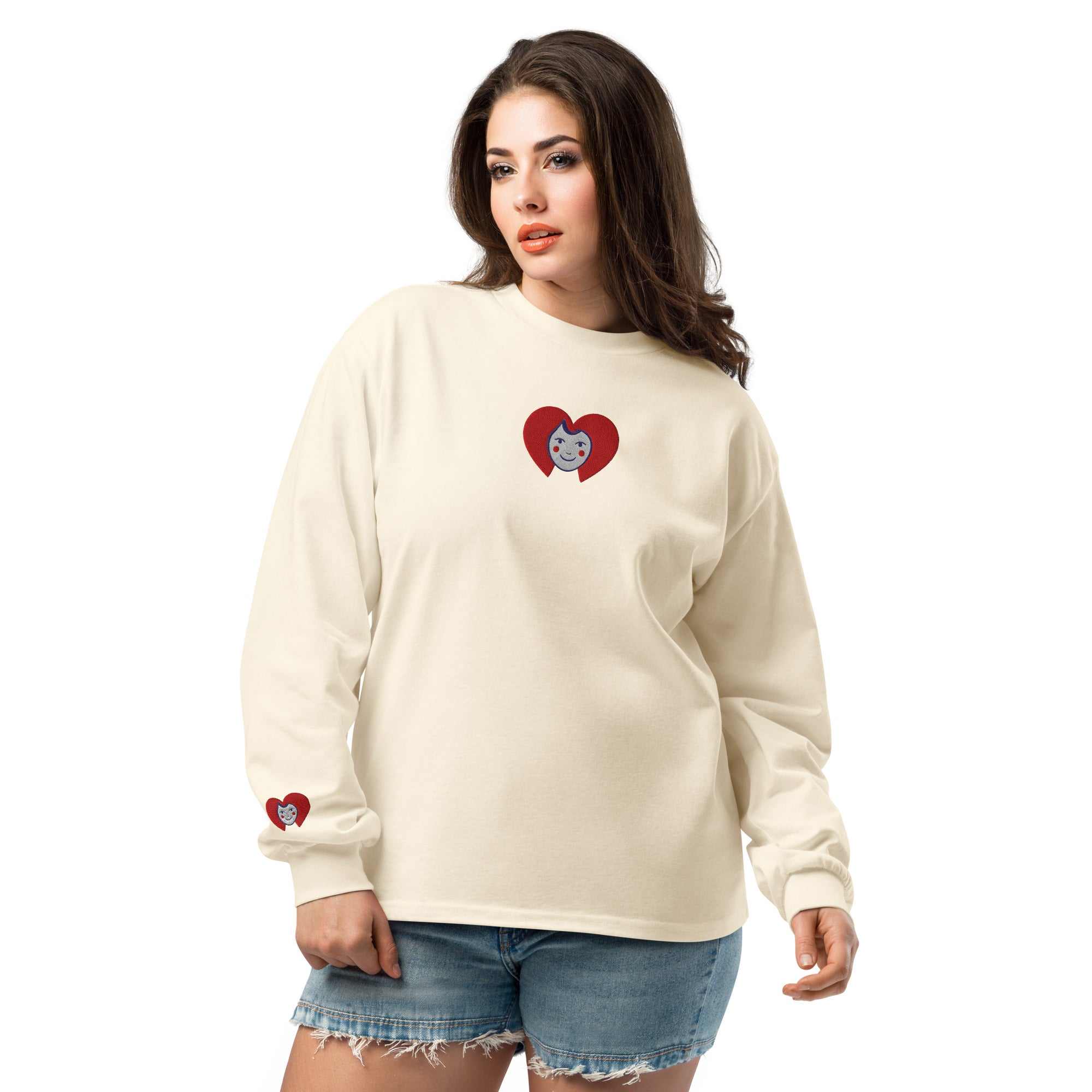 Woman wearing a cream long-sleeve shirt with a heart-shaped logo on a white background