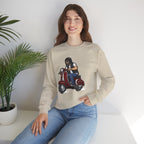 Person wearing a beige sweatshirt with a graphic design of a person on a scooter, sitting in a room with a plant.