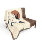 Decorative blanket with artistic design draped over a brown chair on a white background