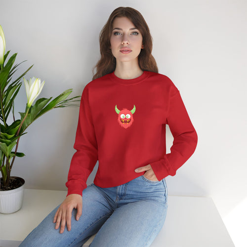 Woman wearing a red sweatshirt with a graphic design, sitting on a white surface with a plant in the background.