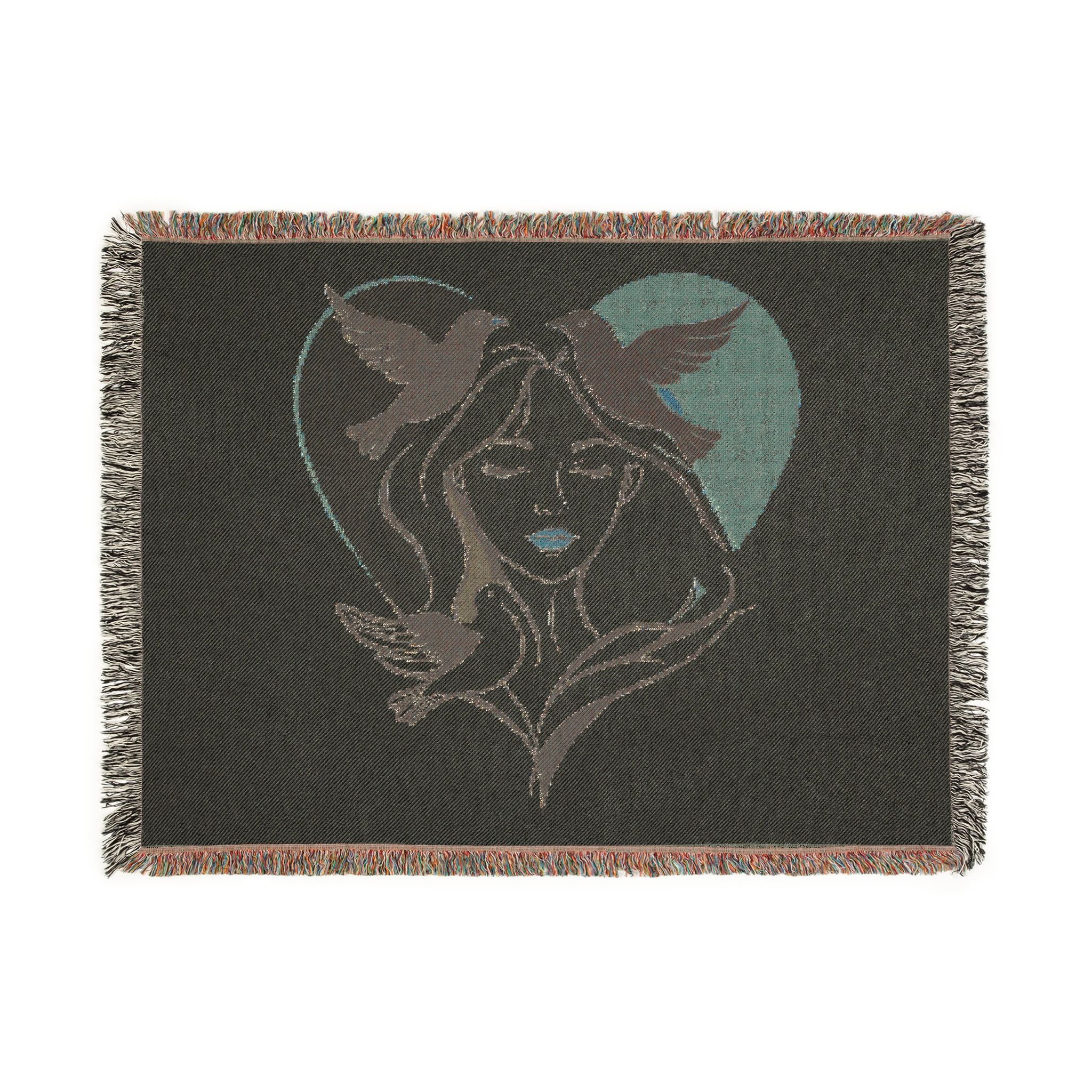 Blanket with a design of a woman's face and birds in a heart shape on a dark background